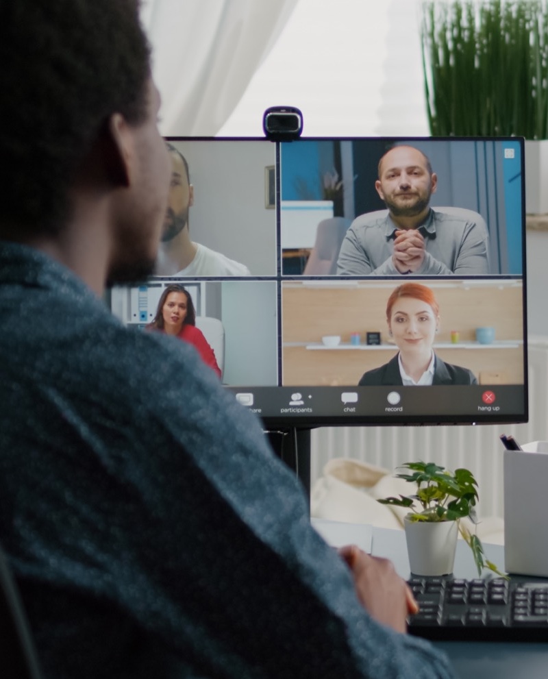 African american man waving to colleagues, talking on online conference internet call using webcam communication. Remote worker working from home keeping distance while using technology